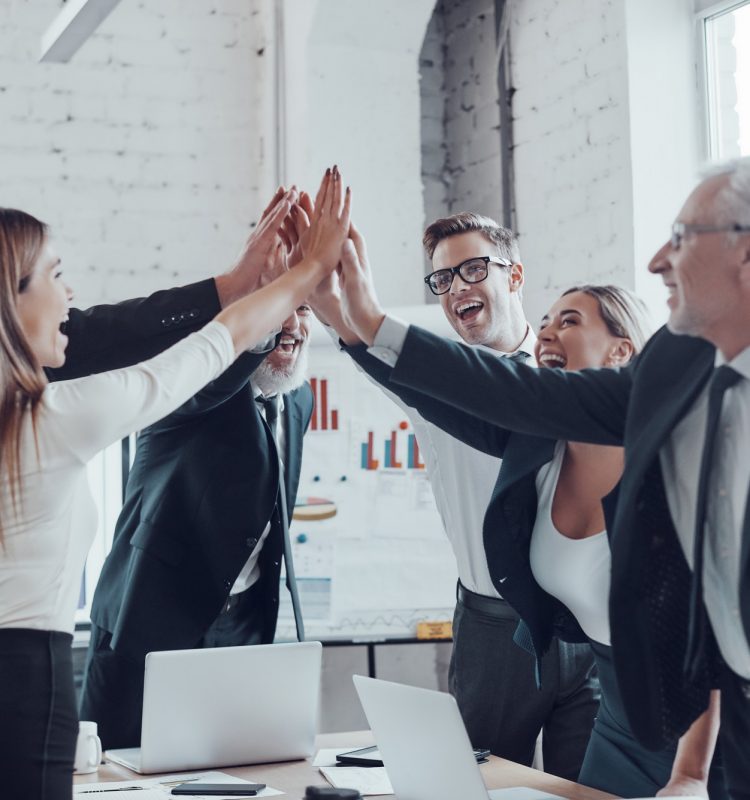 cheerful-business-team-giving-each-other-high-five-to-success-while-working-in-the-modern-office.jpg